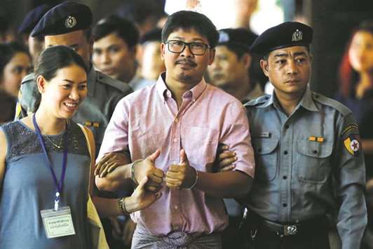 Detained Reuters journalist Wa Lone is escorted by police before a court hearing in Yangon yesterday.