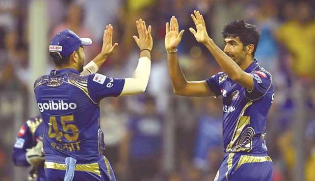 Mumbai Indians captain Rohit Sharma (left) celebrates the wicket of Kings XI Punjab player Marcus Stoinis with teammate Jasprit Bumrah during their Indian Premier League match at the Wankhede Stadium in Mumbai yesterday. (AFP)