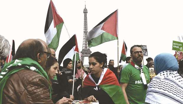 People holding up Palestinian flags rally at the Trocadero in the French capital Paris yesterday.