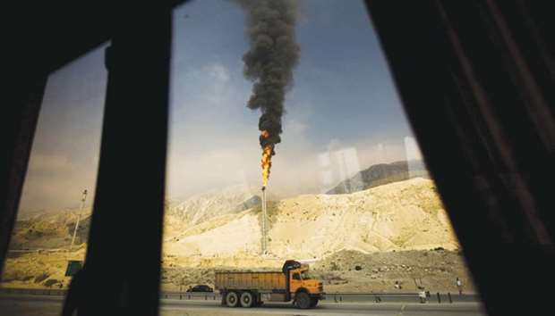 A gas flame is seen through a bus window in the South Pars gas field facilities in the southern Iranian port of Assaluyeh (file). Total, which also buys crude oil for its refineries from Iran, wonu2019t commit any more funds to Iranu2019s South Pars 11 project, in which it took a controlling stake last year, the company said.