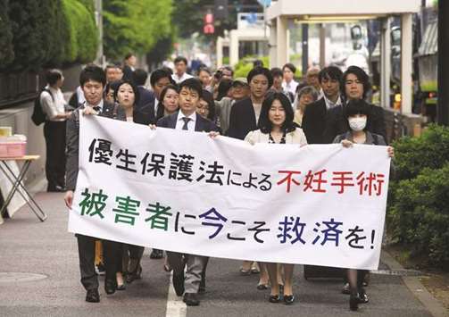 Lawyers and supporters of victims of forced sterilisation under a now-defunct eugenics law, carry a banner saying u201cSterilisation under the eugenics law in Tokyo yesterday.