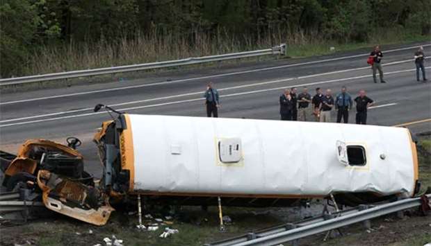 Police stand near the wreckage of a school bus on Interstate 80 following an accident with a dump truck in Mount Olive Township, New Jersey on Thursday.