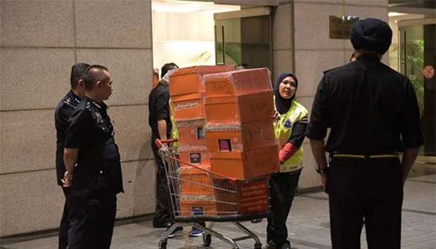 Royal Malaysian police taking away boxes of seized goods during a raid in Kuala Lumpur early on Friday on three luxury apartments owned by former prime minister Najib Razaku2019s family. This photograph was made available by Singapore's Straits Times.