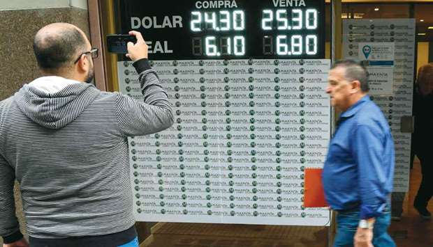 Currency exchange values are displayed in the buy-sell board of a bureau de exchange in Buenos Aires. Argentinau2019s peso plummeted by more than 6% on Monday, sparking new inflation fears for Latin Americau2019s third-largest economy. The currency fell 6.6% to trade at 25.20 against the dollar as markets opened.