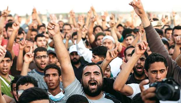 Palestinian demonstrators shout slogans during clashes with Israeli forces along the border with the Gaza Strip, east of Gaza city, yesterday.