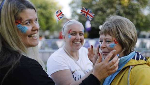 Well-wishers paint their faces on the Long Walk leading to Windsor Castle ahead of the wedding and carriage procession of Prince Harry and Meghan Markle in Windsor on Saturday.