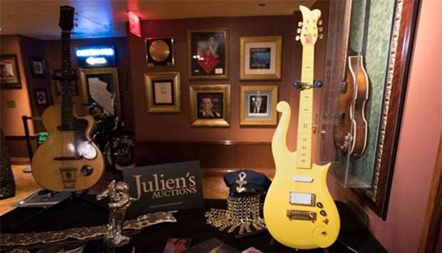 Prince's ,Yellow Cloud, guitar (right) and George Harrison's first electric guitar, the Hofner Club 40, displayed along with other items during a media preview in New York.
