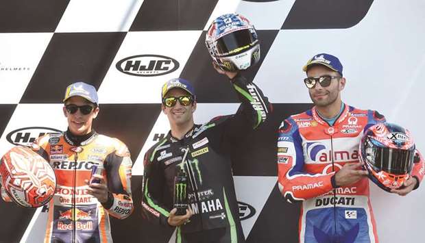 Monster Yamaha Tech 3u2019s French rider Johann Zarco (centre) celebrates on the podium after he clocked the pole position ahead of Repsol Honda Teamu2019s Spanish rider Marc Marquez (left) and Ducati Alma Pramac Racingu2019s Italian rider Danilo Petrucci (right) after the qualifying session for the French MotoGP Grand Prix in Le Mans yesterday.  (AFP)