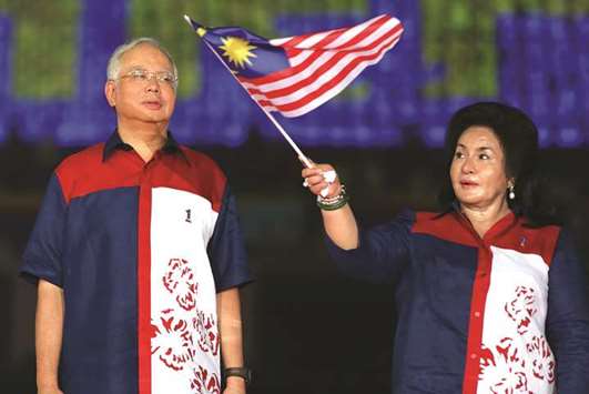 Malaysiau2019s Prime Minister Najib Razak looking on as his wife Rosmah Mansor waves the Malaysia national flag in a file photo.