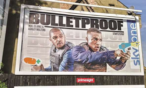 The billboard poster in Walthamstow with a carrot and a hairdryer in place of the firearms.