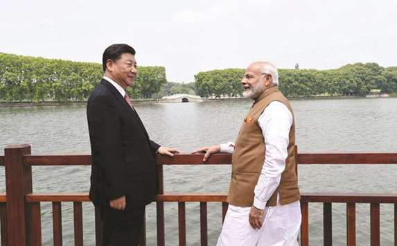 Chinese President Xi Jinping and Indiau2019s Prime Minister Narendra Modi speak as they walk along the East Lake in Wuhan, China on April 28. Threatened by looming trade sanctions from Washington, China is seeking support from other nations to counter US pressure.