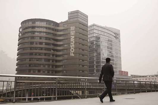 A pedestrian walks across a footbridge in front of the Fosun International headquarters in Shanghai. The Chinese conglomerate is looking to gain a bigger foothold in North Americau2019s tourism and leisure market through acquisitions, as the owner of Club Med SAS launches a new product line for China.