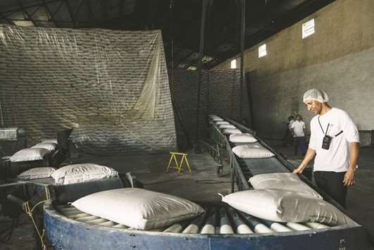 Sugar bags are transported on a conveyor belt at Biosevu2019s Santa Elisa mill in Sertaozinho, Brazil (file). Record sugar production in India and Thailand is weighing heavily on millers in Brazil, the worldu2019s top producer.