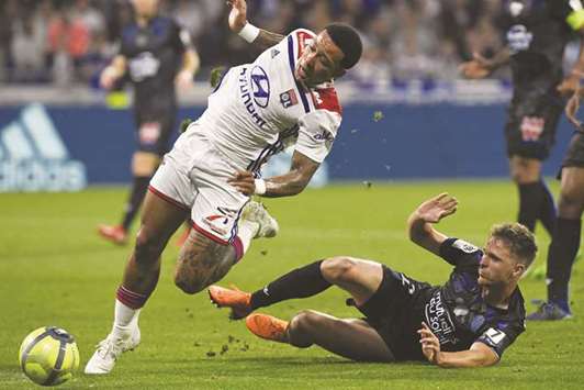 Lyonu2019s Memphis Depay (left) is fouled by Niceu2019s Arnaud Souquet during the French Ligue 1 match on Saturday night. (AFP)
