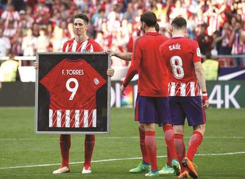 Atletico Madridu2019s Fernando Torres poses with a framed jersey signed by teammates during a tribute at the end of La Liga match against Eibar in Madrid. (AFP)