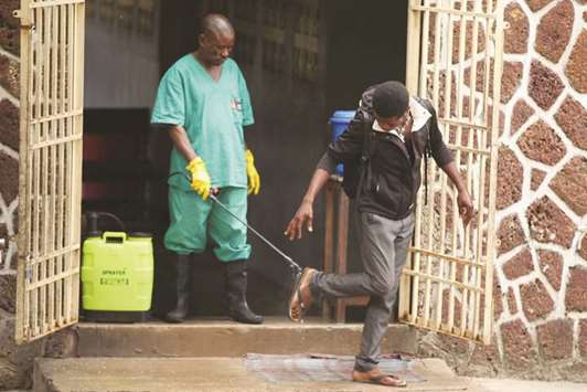 A health worker sprays a visitor with chlorine after leaving the isolation facility at the Mbandaka General Hospital.