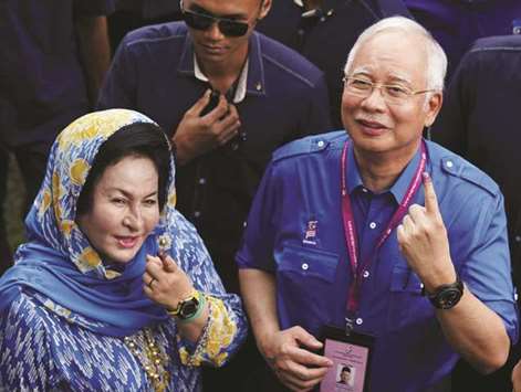 In this file picture, Malaysiau2019s Prime Minister Najib Razak of Barisan Nasional (National Front) and his wife Rosmah Mansor show their ink-stained fingers after voting in Malaysiau2019s general election in Pekan.