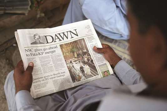 A man reads a copy of the Dawn newspaper yesterday at a newsstand in Karachi.