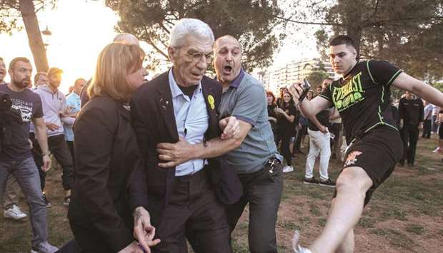 Boutaris is kicked by a suspected far-right member as he is being escorted away from a rally in Thessaloniki on Saturday.
