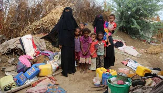 Yemeni families stand in the remains of houses affected by Cyclone Sagar, in the port city of Hodeidah.