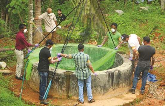 Animal husbandry department and forest officials cover a well with net to catch bats at Changaroth in Kozhikode yesterday.