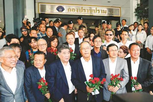Pheu Thai party leaders leave the crime suppression division after being charged with sedition and violating the ban on gatherings, in Bangkok yesterday.