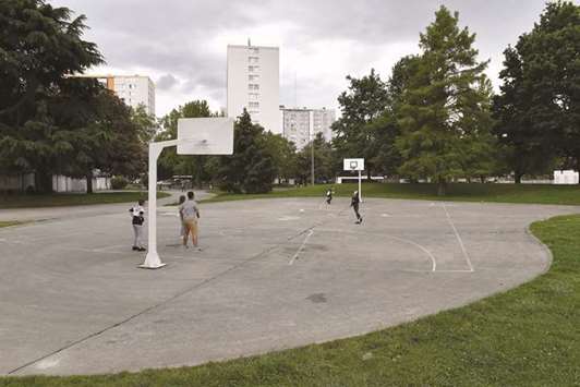 Youths play basketball yesterday at the Plaine des Jeux in the Saragosse neighbourhood of Pau, southwestern France, where a 32-year-old was beaten to death by a gang of teenagers on Friday.