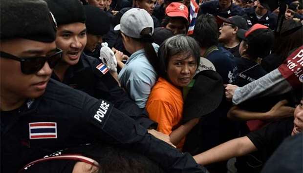 Demonstrators attempt to break through a phalanx of police outside Thammasat University during a protest to mark the fourth year of junta rule in Bangkok on Tuesday.