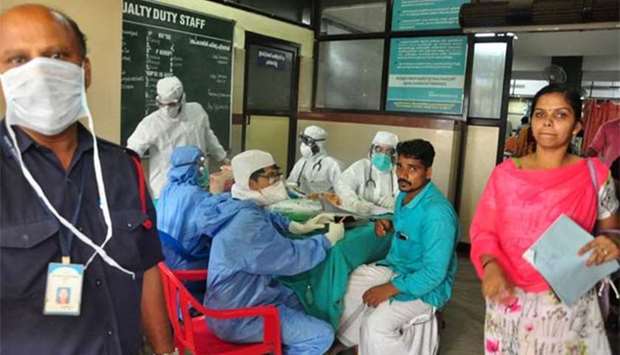 Medics wearing protective gear examine a patient at a hospital in Kozhikode in Kerala on Monday.