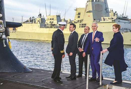 French President Emmanuel Macron and Australian Prime Minister Malcolm Turnbull stand on the deck of HMAS Waller, a Collins-class submarine operated by the Royal Australian Navy, at Garden Island in Sydney yesterday.