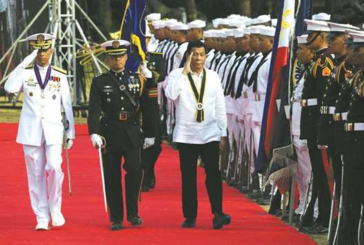 President Rodrigo Duterte salutes along with navy chief Vice Admiral Robert Empedrad (left) as they inspect the honour guard during a ceremony as part of the 120th Philippine navy anniversary celebration in Manila, yesterday.