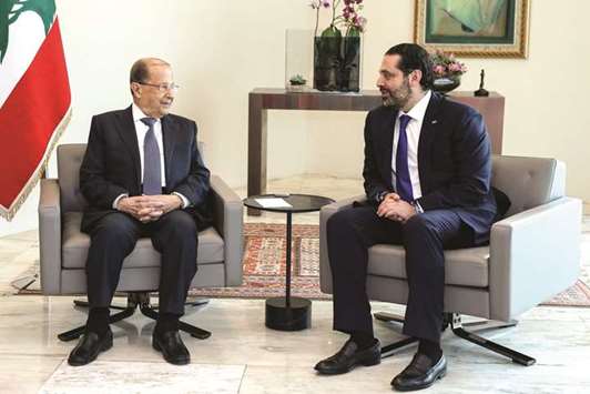 Lebanese President Michel Aoun speaks to Prime Minister Saad Hariri during a meeting at the presidential palace in Baabda, east of the capital Beirut.