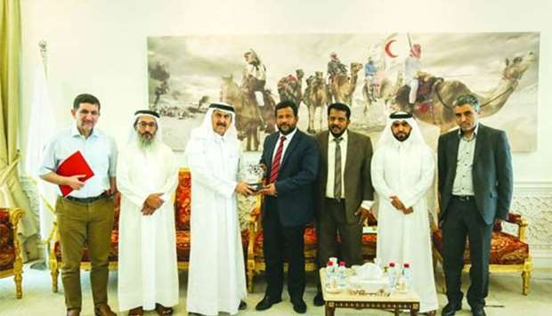 Sri Lankau2019s Minister of Industry and Commerce Rishad Bathiudeen receiving a memento from QRCS secretary general Ali bin Hassan al-Hammadi as other officials look on.
