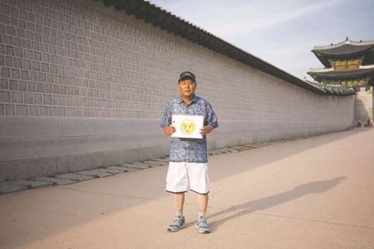 Retiree Noh Yong-taek (66) poses for a photo holding an emoji after being asked to chose one that he felt best represented his feelings following US President Donald Trumpu2019s abrupt decision to cancel a summit with North Korean leader Kim Jong-un, at Gyeongbokgung palace in central Seoul.