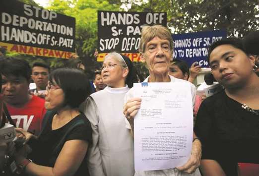 Australian missionary Patricia Fox holds a copy of a petition calling for the review of her deportation case at the Department of Justice, after the immigration bureau voided her visa following complaints from President Rodrigo Duterte about her participation in protest rallies, in Padre Faura, Metro Manila, yesterday.