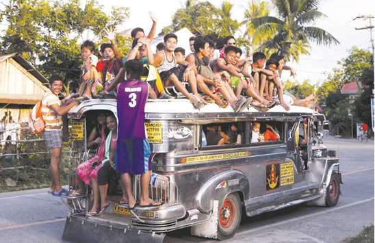 File photo shows residents riding on top of an overcrowded u201cJeepneyu201d, a locally manufactured public transport, along a highway in Mogpog town on Marinduque island in central Philippines