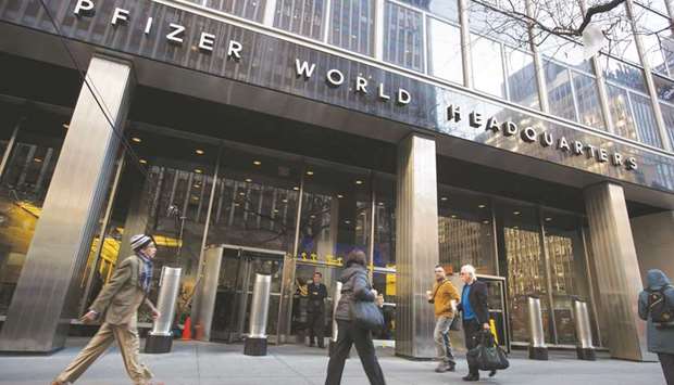 Pedestrians walk past Pfizer headquarters in New York. Companies led by Pfizer and Amgen bought back a combined $16.7bn in the most recent quarter, according to data compiled by Bloomberg.