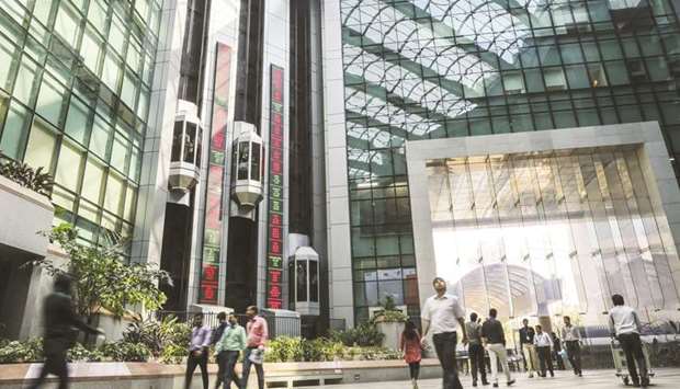 Employees walk past electronic boards displaying stock figures in the atrium of the National Stock Exchange of India building in Mumbai. A fight between the Singapore Exchange and the NSE over derivatives contracts is threatening to end a popular way of hedging Indian shares.