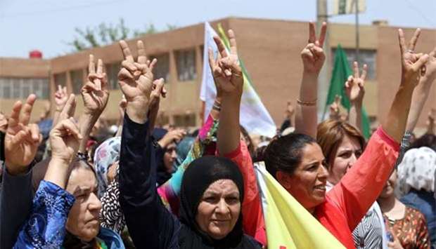 Syrian-Kurdish people demonstrate against demographic changes forced by Turkey to repopulate Kurdish areas, in Qamishli on Saturday.