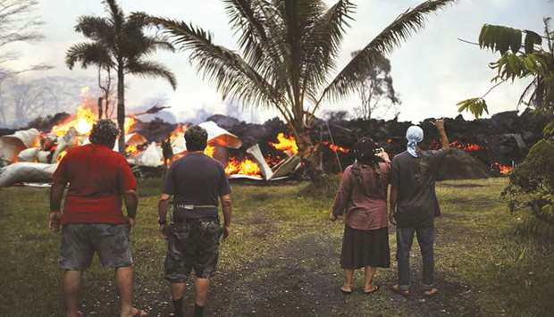 Community members watch as a home is destroyed by lava from the Kilauea volcano fissure in Leilani Estates, on Hawaiiu2019s Big Island, on Friday.