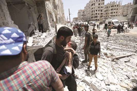 A man carries a wounded child out of a building following a car bomb explosion in the northern Syrian city of Idlib, yesterday.