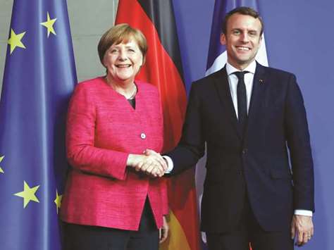 File photo of German Chancellor Angela Merkel and French President Emmanuel Macron shaking hands after a news conference at the Chancellery in Berlin. Though Chancellor Angela Merkel often lavishes Macron with praise for his courage and policy goals, she seems reluctant to agree to any action to strengthen the EU.