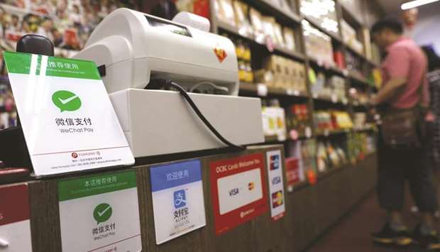 Signs accepting WeChat Pay and AliPay are displayed at a shop in Singapore. By last yearu2019s fourth quarter, payment apps handled 37.7tn yuan ($5.9tn) of spending in China, up 28% from just three months earlier, according to research firm  Analysys International. Alipay handled 54% of that, followed by Tencentu2019s 38%.