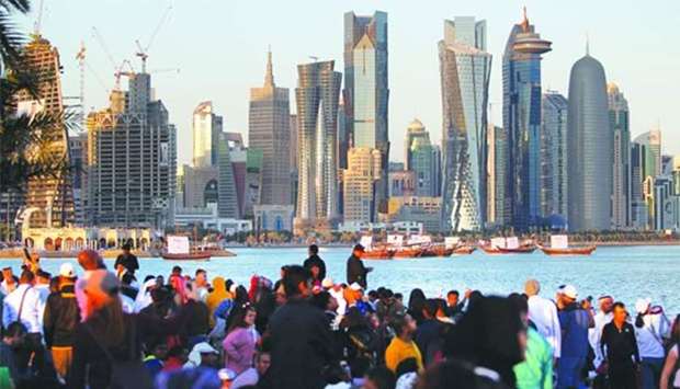People take part in the Qatar National Day celebrations in Doha on December 18, 2017. The new law would provide ,many guarantees that enhance the investment environment and allows investment in banks and insurance companies by a cabinet decision, provides for an increase in the State's tax revenues.,
