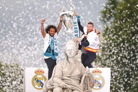 Real Madridu2019s Marcelo (left) and Sergio Ramos hold the trophy at Cibeles square in Madrid as they celebrate their Champions League title victory yesterday. (AFP)