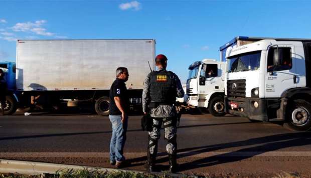 A police officer take position as they order truckers to clear the blocked BR-04 highway in Luziania, Brazil