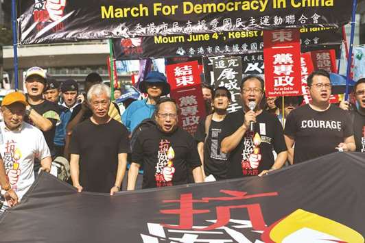 Protesters hold a banner which reads u201cMarch For Democracy in Chinau201d as they take part in a march in Hong Kong yesterday.