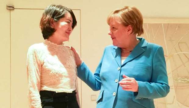 German Chancellor Angela Merkel (R) speaking with Li Wenzu in Beijing