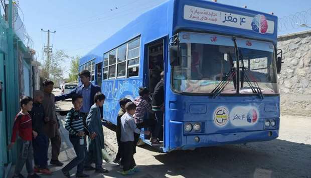 Afghan children board a mobile library bus in Kabul