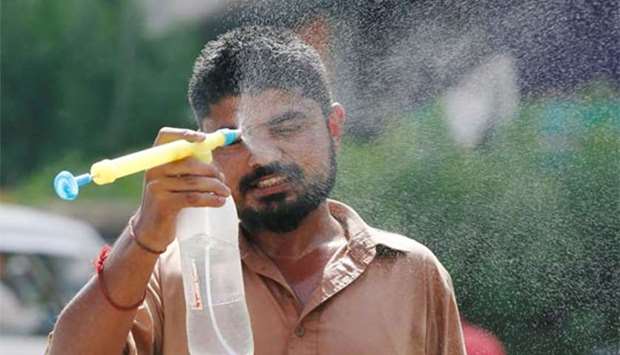 A man uses a water mist sprayer to cool down from the heatwave in Karachi on Monday.